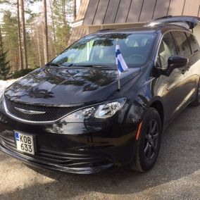 Mustaa hautausautoa koristaa Suomen lippu.