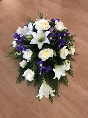 hautajaiskimppu, jossa liiloja ja valkoisia kukkia