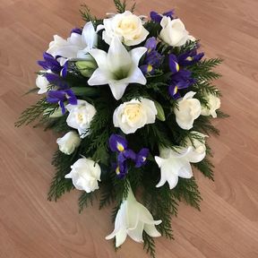hautajaiskimppu, jossa liiloja ja valkoisia kukkia